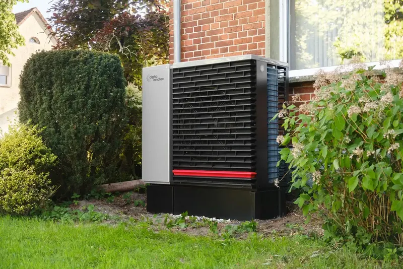 Buitenunit van een warmtepomp in de tuin