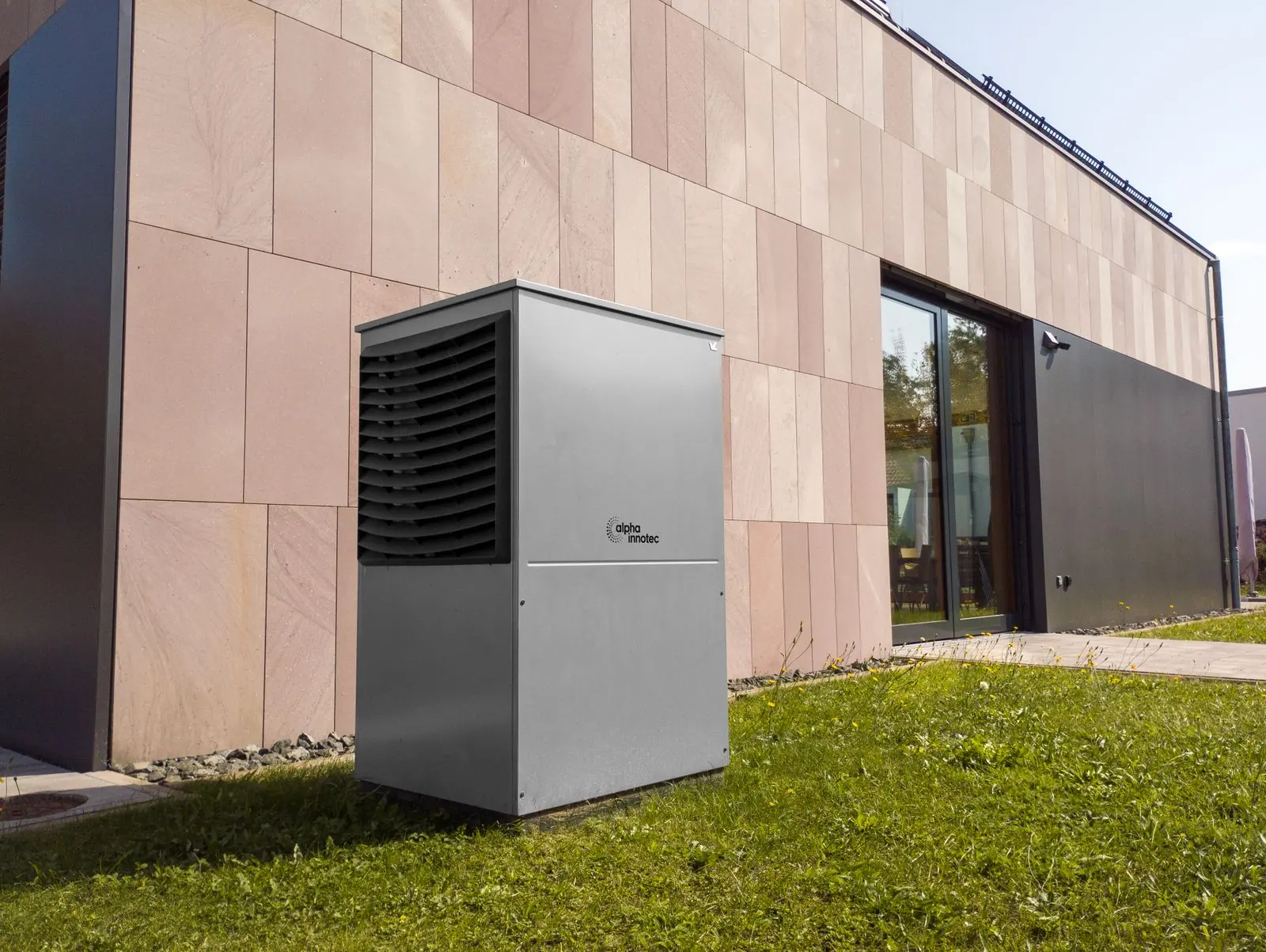 Moderne woning met een warmtepomp-buitenunit tegen de gevel